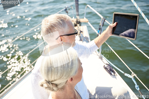 Image of senior couple with tablet pc on sail boat or yacht