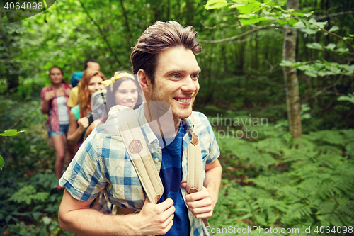 Image of group of smiling friends with backpacks hiking