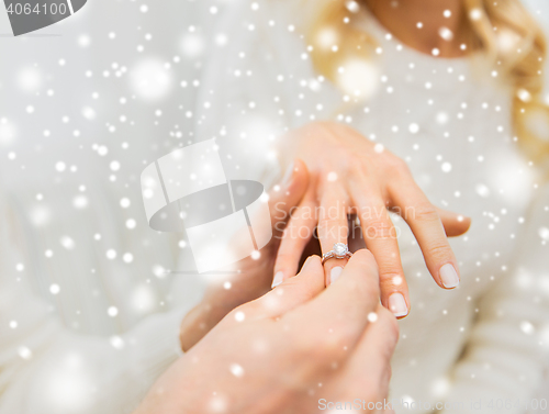 Image of close up of man giving diamond ring to woman