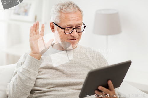 Image of senior man having video call on tablet pc at home