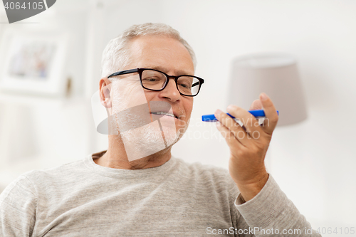 Image of old man using voice command recorder on smartphone