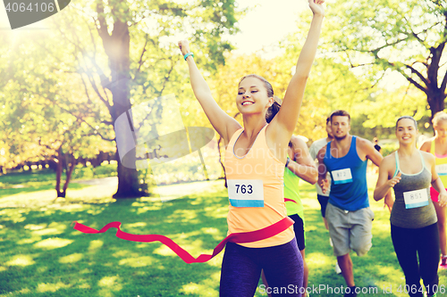 Image of happy young female runner winning on race finish