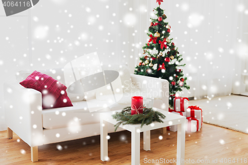 Image of sofa, table and christmas tree with gifts at home