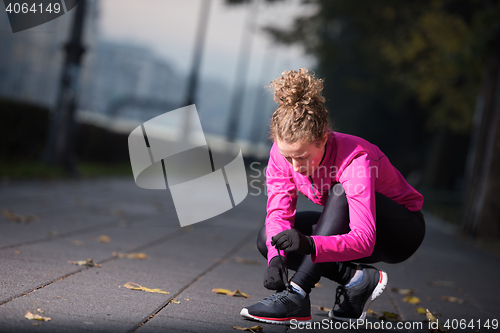 Image of woman  stretching before morning jogging