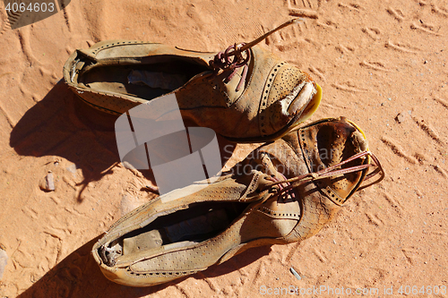 Image of old pair of shoes on sand