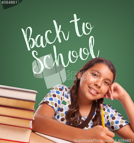 Image of Cute Hispanic Girl Studying In Front of Back To School Written o