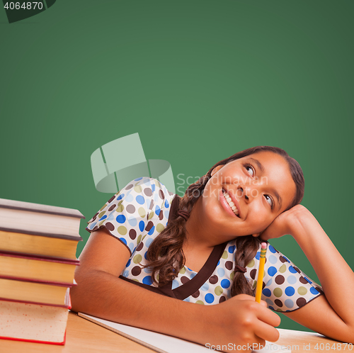 Image of Cute Hispanic Girl Studying Looking Up to Blank Chalk Board