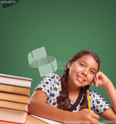 Image of Cute Hispanic Girl StudyingIn Front of Blank Chalk Board