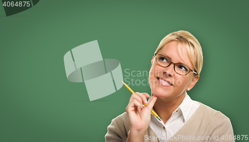 Image of Attractive Young Woman with Pencil In Front of Blank Chalk Board