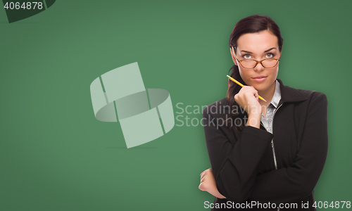 Image of Serious Young Woman with Pencil In Front of Blank Chalk Board