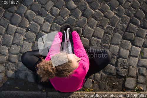 Image of woman  stretching before morning jogging