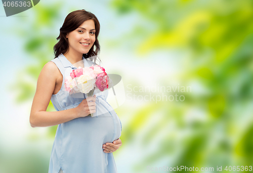 Image of happy pregnant woman with flowers touching belly