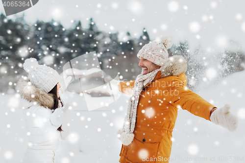 Image of happy couple playing with snow in winter