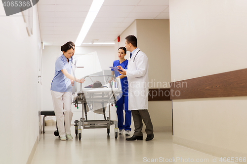 Image of medics with woman on hospital gurney at emergency