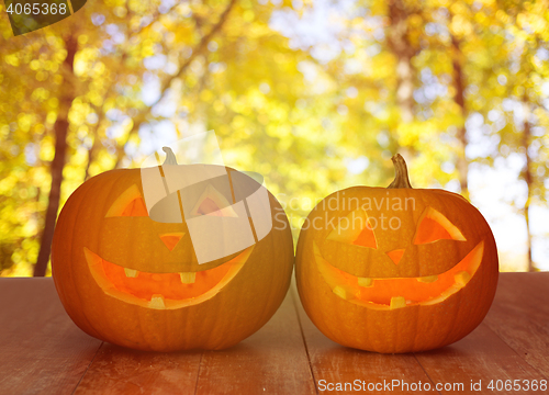 Image of close up of pumpkins on wooden table outdoors