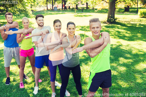 Image of group of friends or sportsmen exercising outdoors