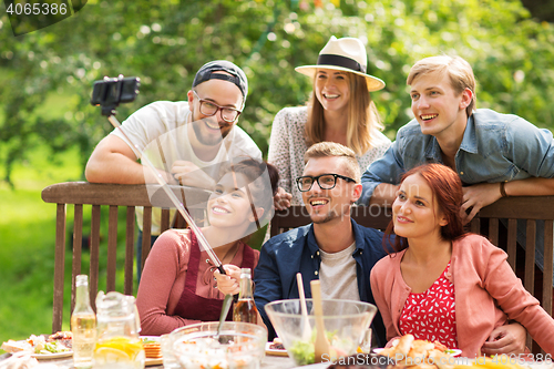 Image of friends taking selfie at party in summer garden