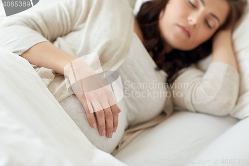 Image of pregnant woman sleeping in bed at home