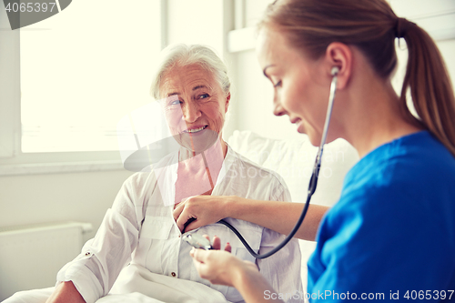 Image of nurse with stethoscope and senior woman at clinic