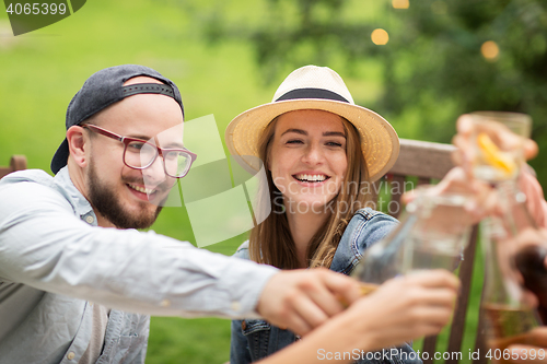 Image of happy friends clinking glasses at summer garden