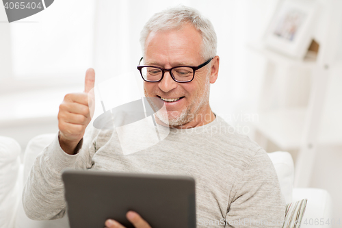 Image of senior man having video call on tablet pc at home