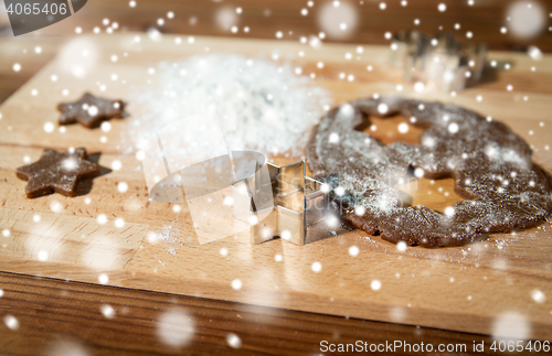 Image of close up of ginger dough, molds and flour on board