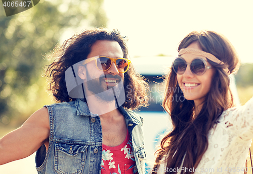 Image of smiling young hippie couple over minivan car