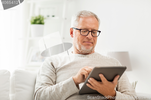 Image of senior man with tablet pc at home