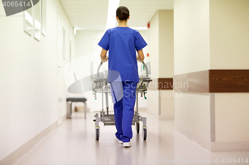 Image of nurse carrying hospital gurney to emergency room