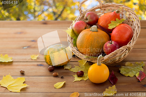 Image of close up of pumpkins in basket on wooden table