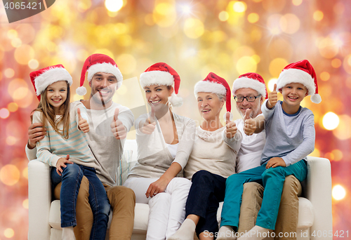 Image of happy family in santa hats showing thumbs up