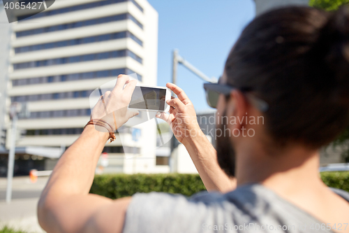 Image of hipster man taking picture on smartphone