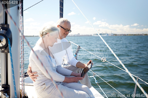 Image of senior couple with tablet pc on sail boat or yacht