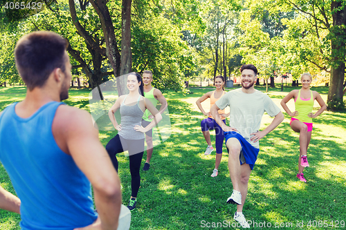 Image of group of friends or sportsmen exercising outdoors