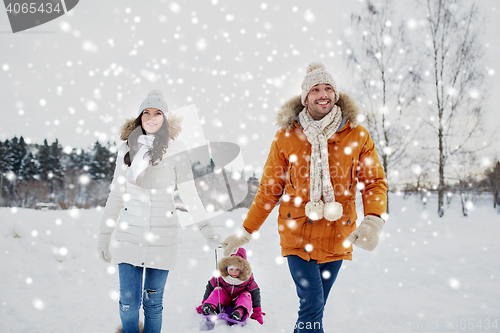 Image of happy family with sled walking in winter outdoors