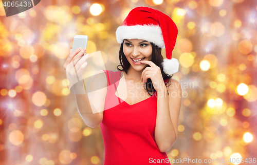 Image of woman in santa hat taking selfie by smartphone