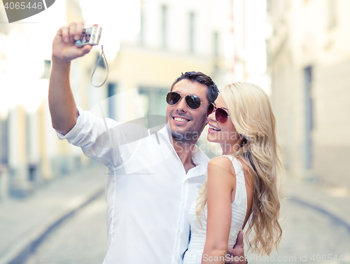 Image of travelling couple taking photo picture with camera