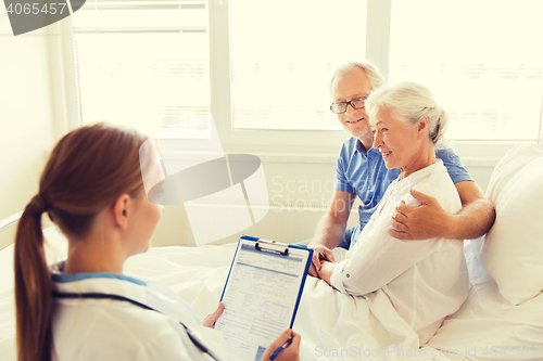 Image of senior woman and doctor with clipboard at hospital
