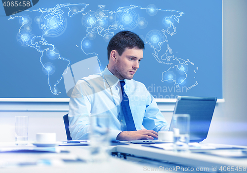 Image of businessman with laptop working in office