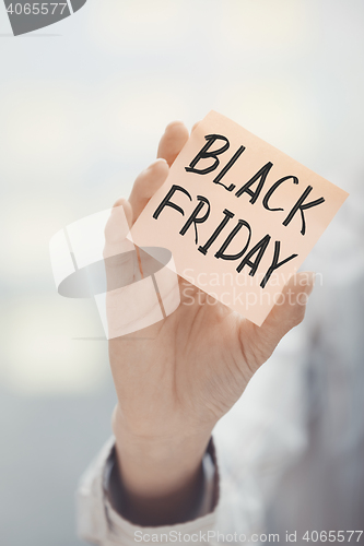 Image of Woman holding adhesive note Black Friday text