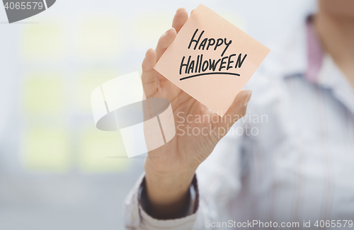 Image of Woman holding agenda with Happy Halloween text