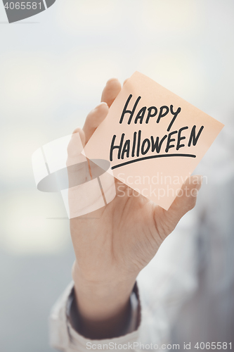 Image of Woman holding agenda with Happy Halloween text