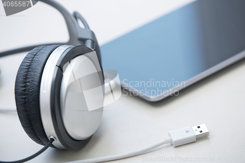 Image of Headphones and tablet computer on a table