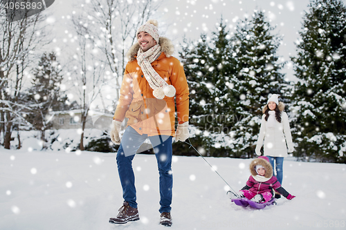 Image of happy family with sled walking in winter outdoors