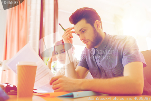 Image of creative team with computer and papers in office
