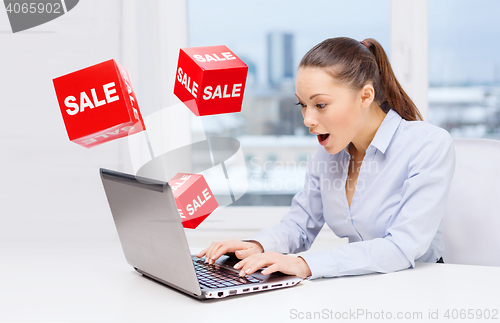 Image of surprised businesswoman with laptop and sale signs