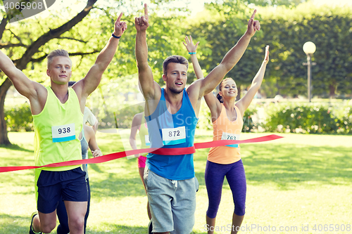 Image of happy young male runner winning on race finish