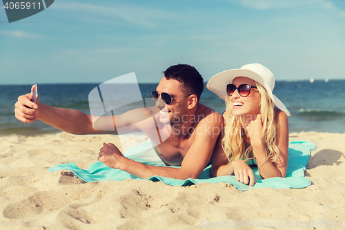 Image of happy couple in swimwear walking on summer beach