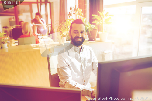 Image of happy creative male office worker with computer