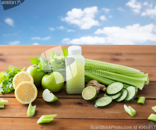 Image of close up of bottle with green juice and vegetables